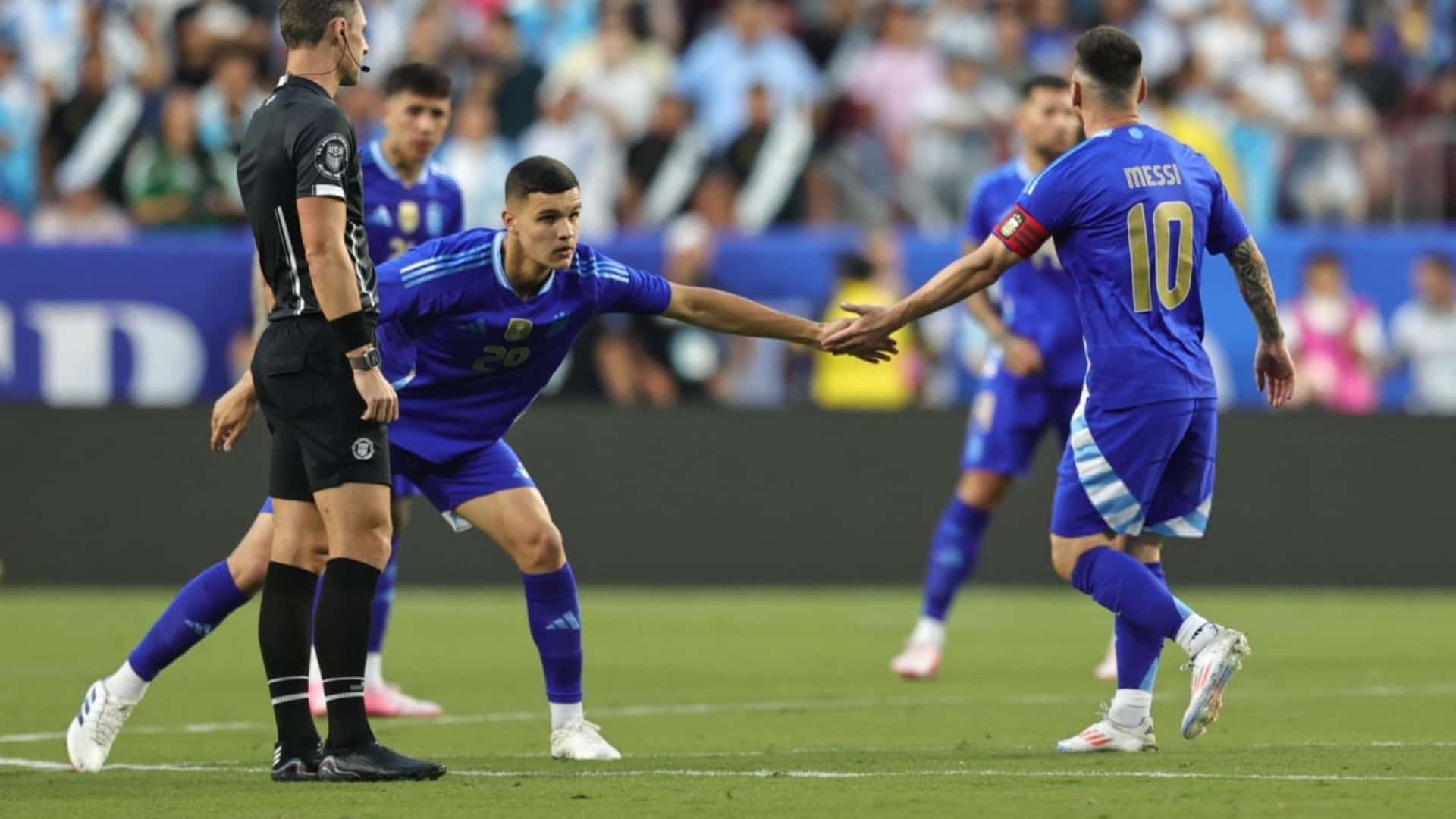 Carboni y Lionel Messi tocan sus manos.