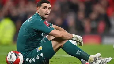 Emiliano Martínez sentado en el verde césped.