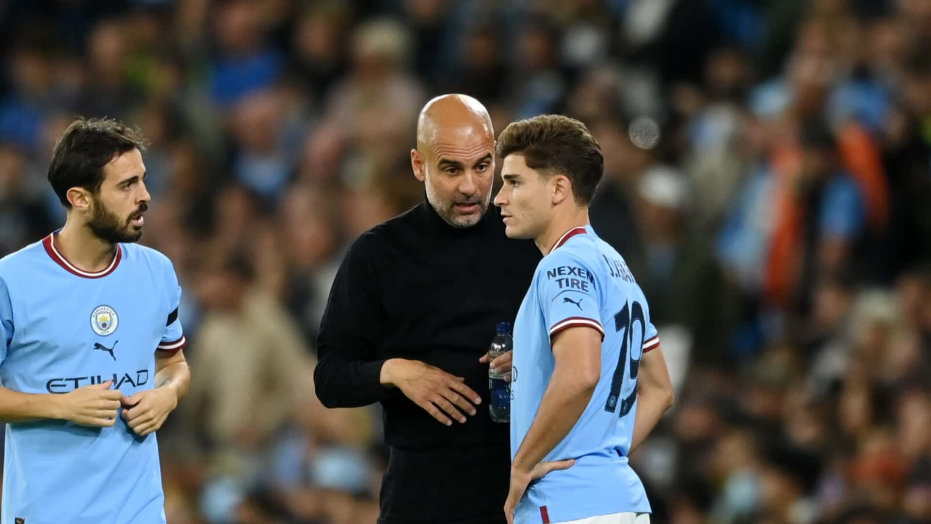 Pep Guardiola dialogando con Julián Álvarez en medio de un partido del Manchester City.